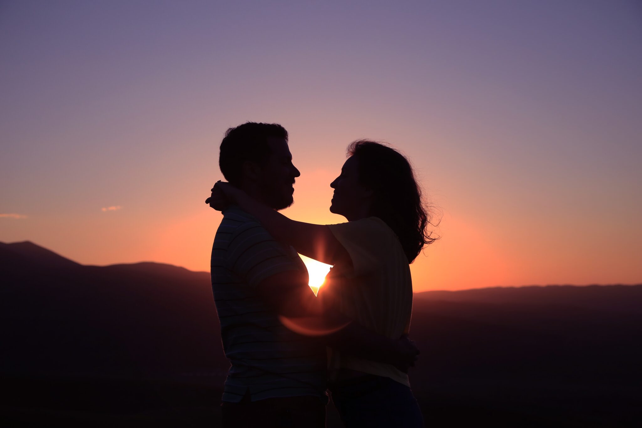 Couple s'embrassant devant coucher de soleil